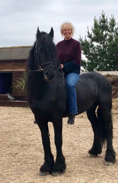 Riding an impressive black Friesian stallion